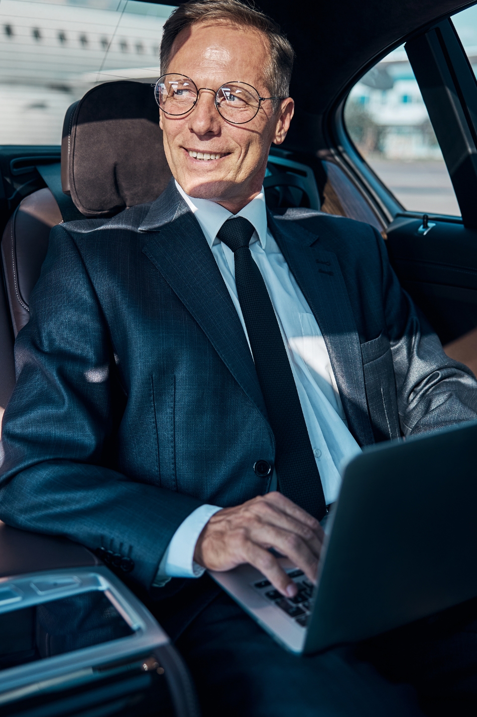 Executive exiting luxury car