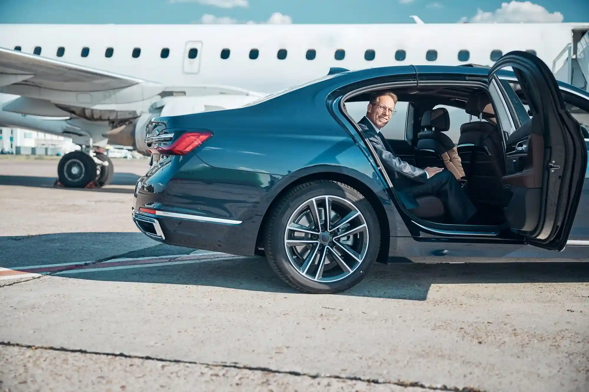 airport transfer-gtcs Seattle airport car service chauffeur assisting client with luggage at Sea-Tac