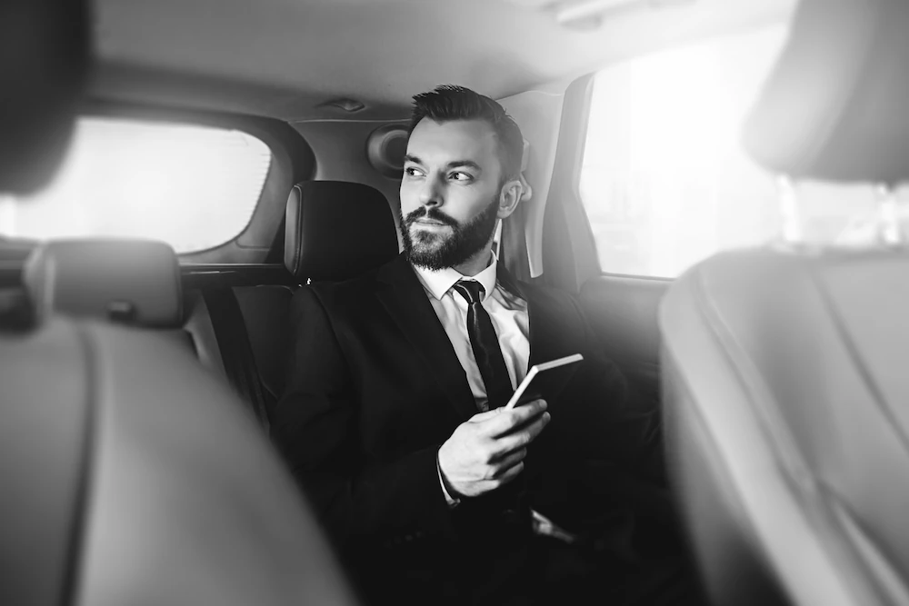 businessman in luxury black car-gtcs Businessman riding in Galaxy Town Car Service luxury black car in Seattle