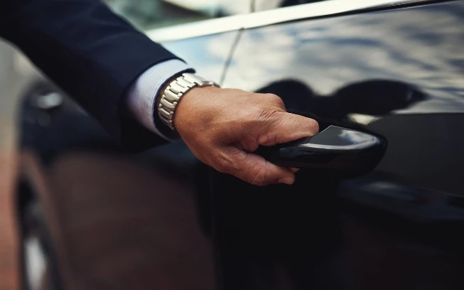 chauffeur opening car door-gtcs Professional Seattle chauffeur opening car door for client